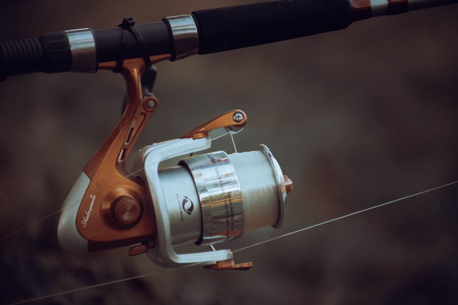 Detailed view of a fishing reel with line tension, showcasing precise fishing equipment mechanics.
